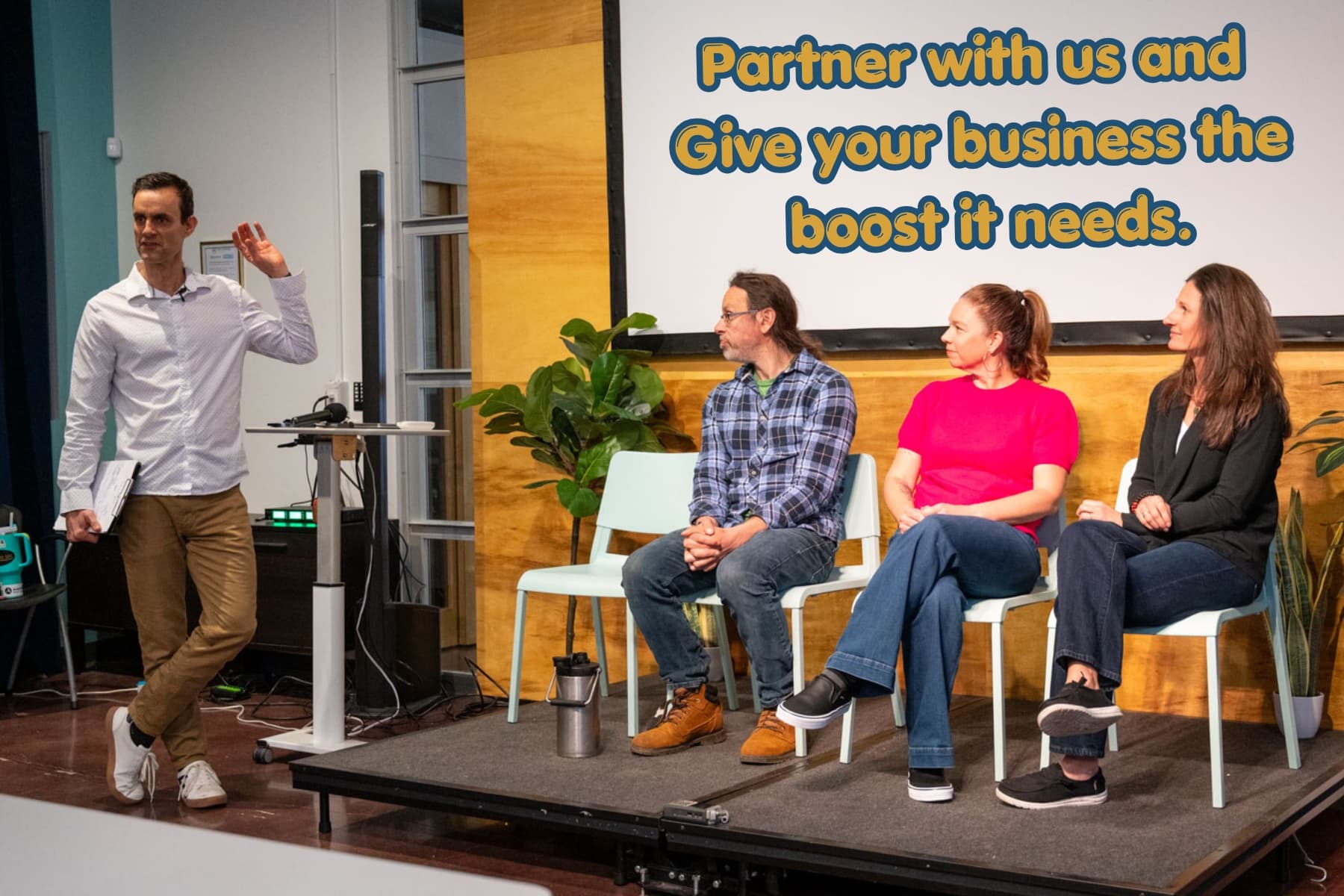 Be Well Asheville founder introducing a panel of partners on stage